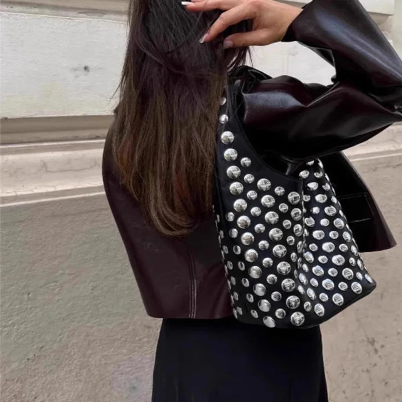 Apportez une touche de sophistication à votre style avec notre sac seau à rivets. Chic, pratique et tendance, il s’adapte à toutes vos occasions avec élégance.