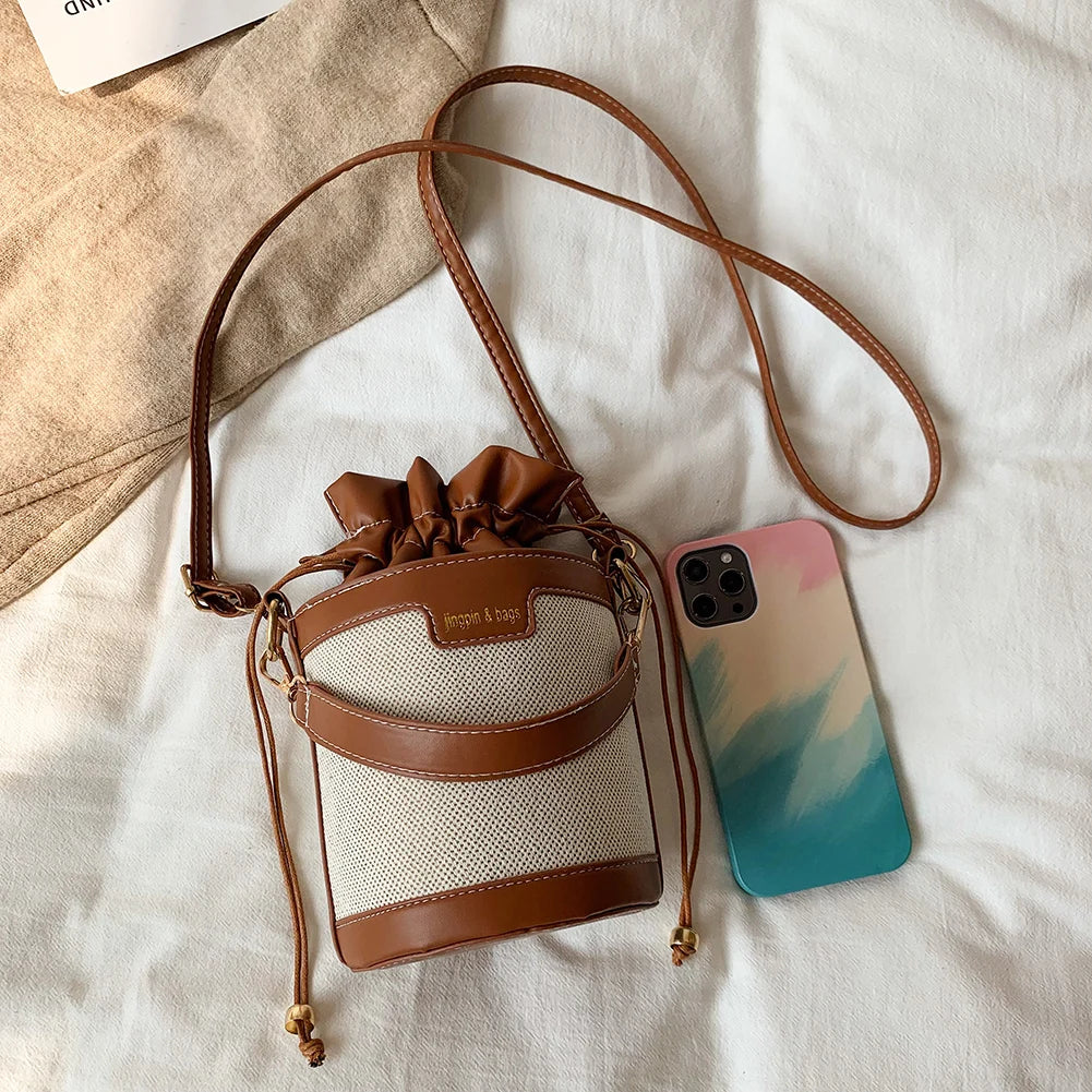 Sac seau en cuir noir avec fermeture à cordon, design élégant et minimaliste pour un usage quotidien.