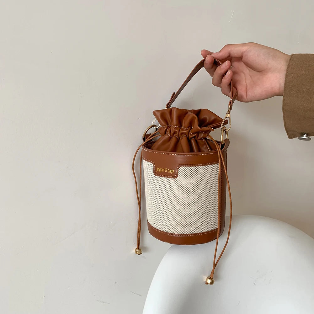 Sac seau en cuir noir avec fermeture à cordon, design élégant et minimaliste pour un usage quotidien.