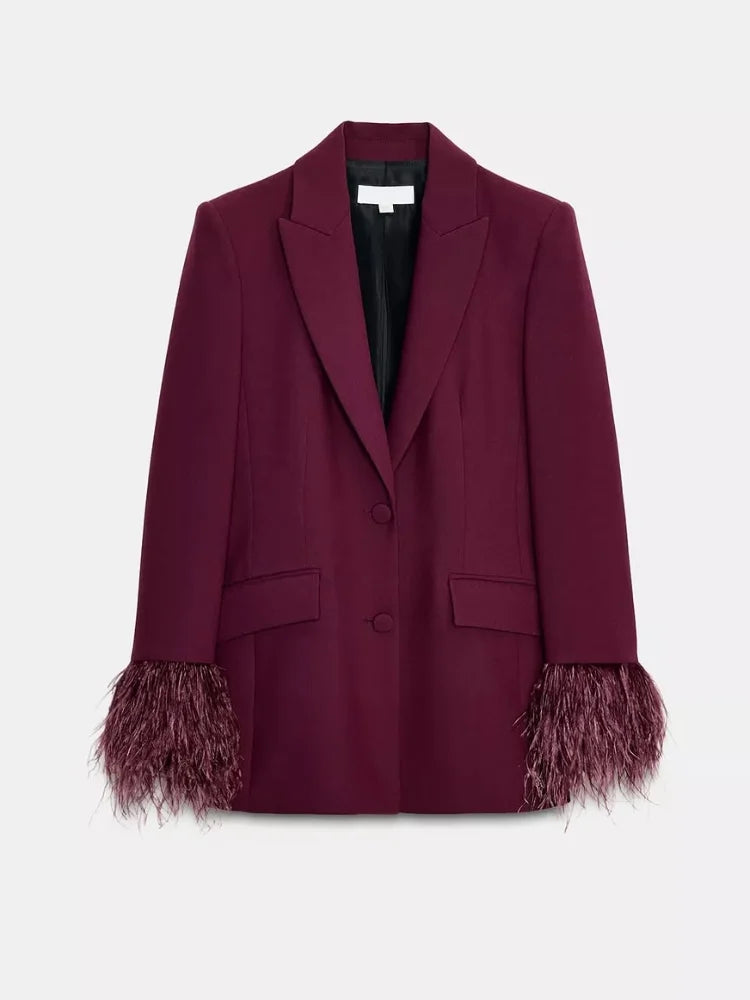 Gros plan sur la précision du col cranté et le revers sculptural d'un blazer de caractère.