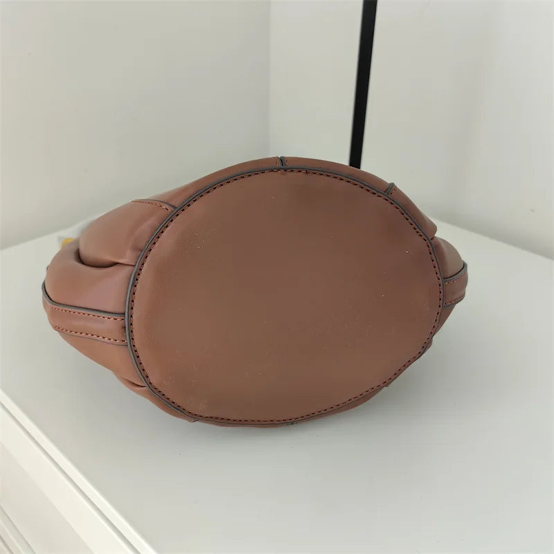 Sac curve en simili cuir marron, forme arrondie avec anse courte élégante.