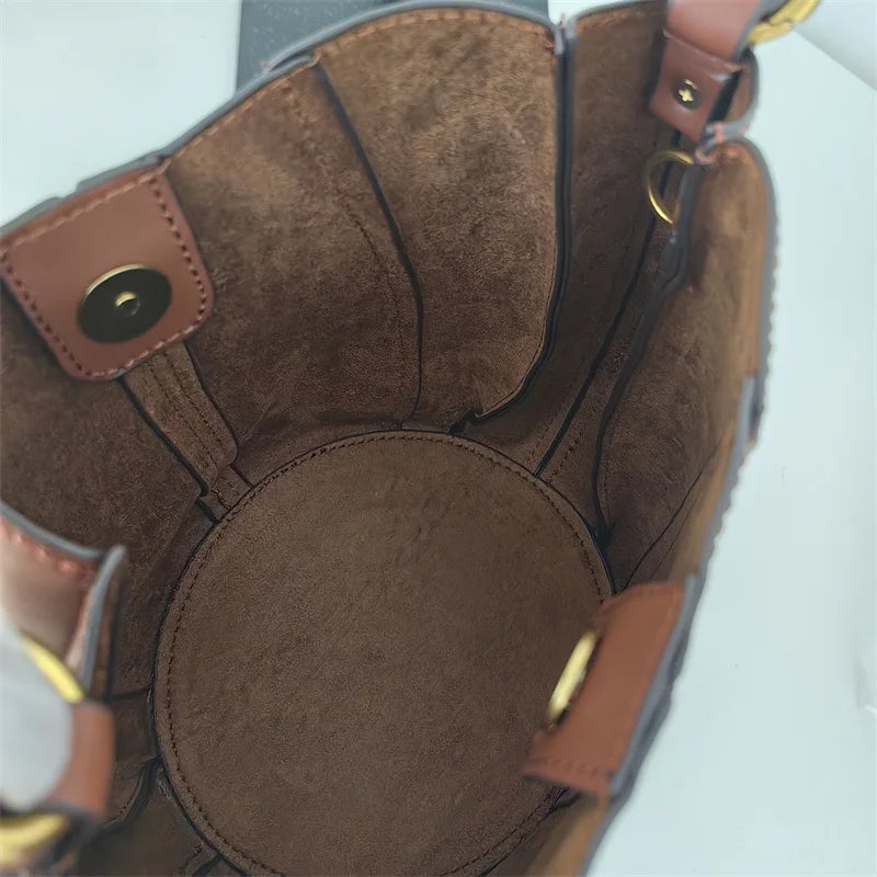 Sac curve en simili cuir marron, forme arrondie avec anse courte élégante.