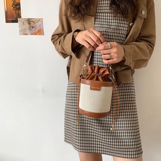 Sac seau en cuir noir avec fermeture à cordon, design élégant et minimaliste pour un usage quotidien.