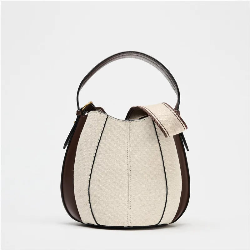 Sac curve en simili cuir bi matière, forme arrondie avec anse courte élégante.
