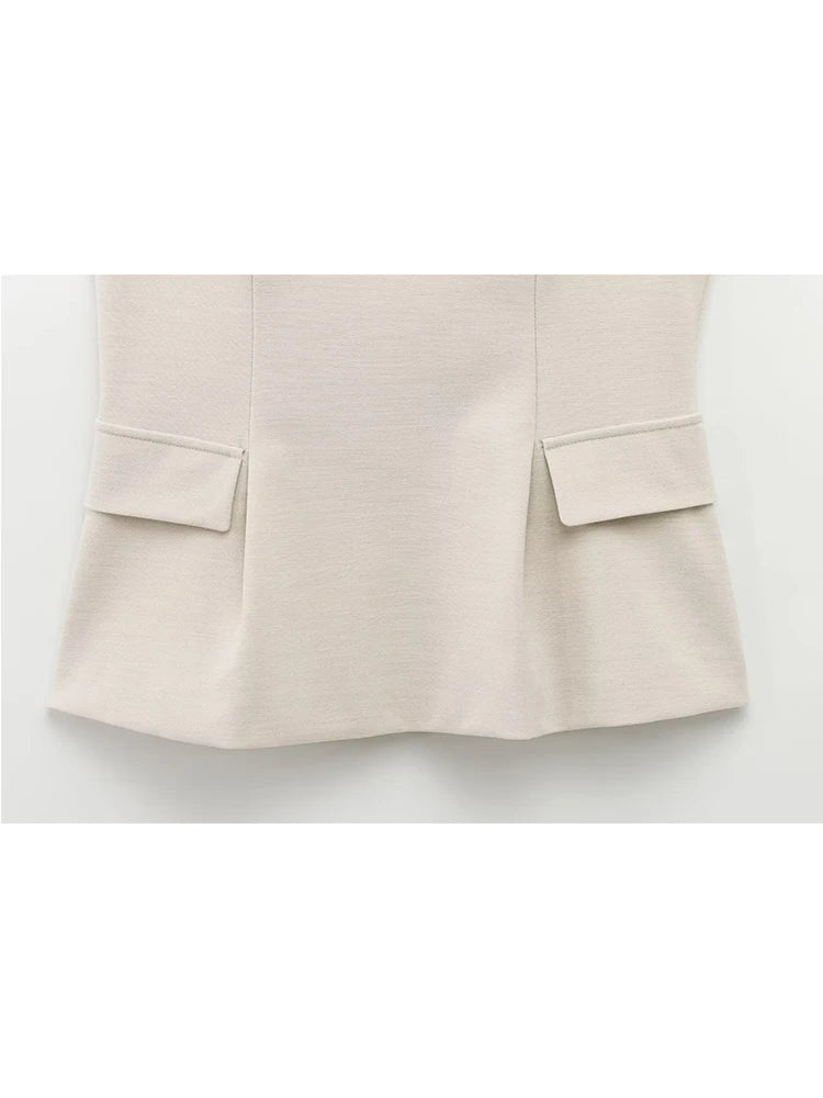 Top peplum beige en tissu stretch, cintré à la taille pour une silhouette féminine.