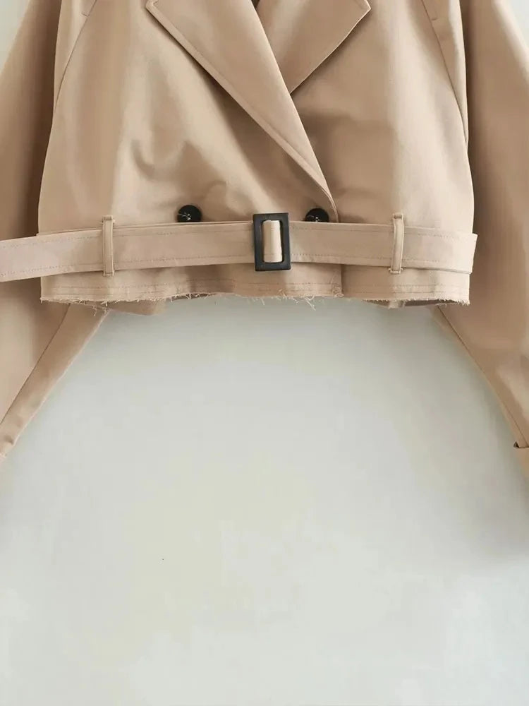 Trench court beige avec ceinture à la taille, look chic et intemporel.